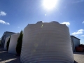 Three white water tanks with sun